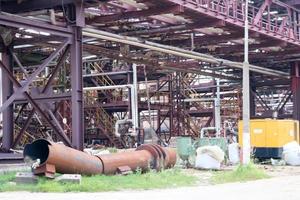 um grande cavalete de tubulação de metal de ferro com tubos e fios elétricos e equipamentos na refinaria petroquímica refinaria industrial foto