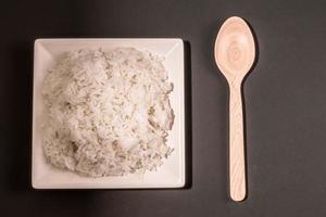 arroz branco de comida saudável asiática no prato na mesa de madeira. foto