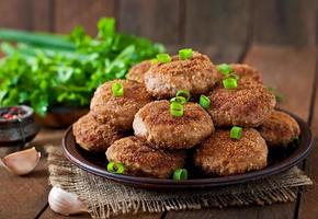 costeletas de carne deliciosas suculentas em uma mesa de madeira em estilo rústico. foto