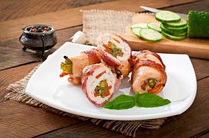 deliciosos rolinhos de frango recheados com feijão verde e cenoura envoltos em tiras de bacon