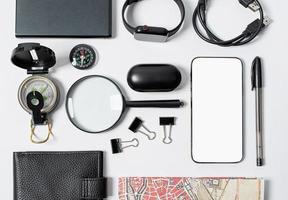 planejamento de viagem, dispositivos de cor preta do viajante na mesa branca foto