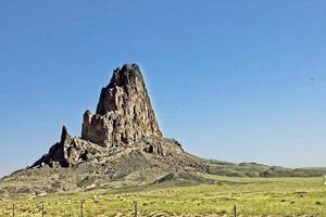 formação rochosa solitária projetando-se para cima do alto deserto do arizona foto