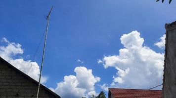 céu azul entre o telhado da casa e a antena da tv foto