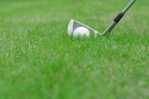 close-up de uma bola de golfe na grama verde de um campo de golfe foto