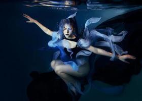 bela jovem artística dançando debaixo d'água. sereia, dança, conceito de fada foto