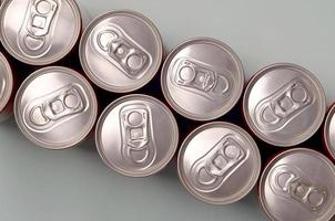 muitas novas latas de alumínio de refrigerantes ou recipientes de bebidas energéticas. conceito de fabricação de bebidas e produção em massa foto