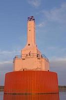 farol de luz em um quebra-mar foto