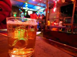 desfocar turva copo frio de cerveja em um bar. foto