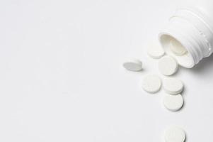 pílulas de remédio branco close-up em fundo branco foto