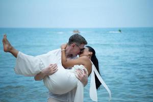 casal interracial com a alegria de viajar para o lindo mar azul como o paraíso foto