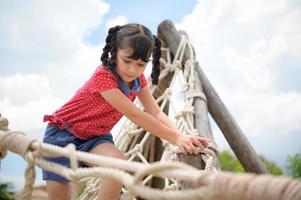 uma garotinha se divertindo balançando em um balanço em um dia claro foto