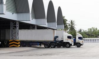 reboque de dois contêineres está carregando carga no armazém. foto