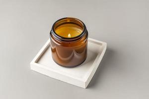 vela artesanal de parafina e cera de soja em frasco de vidro na bandeja de concreto. fabricação de velas. minimalismo foto