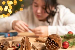 garota faz enfeites de árvore de natal sem papel com as próprias mãos. instrução passo a passo foto