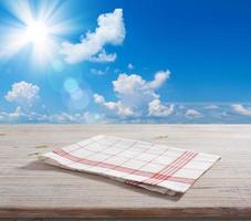 guardanapo branco, toalha de mesa na maquete de deck de madeira. fundo de paisagem de verão. foto