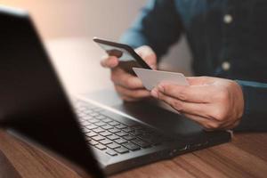 homem usando cartão de crédito para compras e compras online no celular. pagamento móvel com tecnologia de aplicativo de carteira. transferência de dinheiro digital, conceito bancário e comércio eletrônico. foto