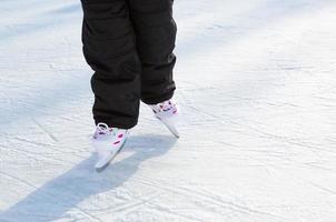 patins deslizantes de plástico infantil com close-up de ajuste de tamanho no gelo no inverno ao ar livre. rolando e deslizando em um dia ensolarado gelado, esportes de inverno ativos e estilo de vida foto