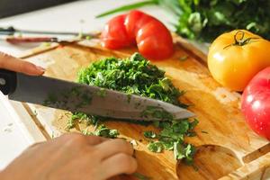 mulher cortando salsa e endro para salada vegetariana saudável foto