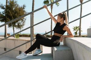 atleta de mulher jovem e sexy durante treino de rua de verão foto