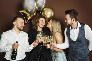 pessoas de festa bem vestidas comemorando feriado ou evento e bebendo vinho espumante foto