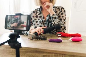 blogueira mulher fazendo vlog e revisando diferentes brinquedos sexuais foto