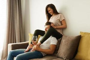 casal feliz bebendo vinho e relaxando em casa foto