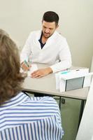 médico e paciente do sexo masculino de meia-idade durante consulta foto