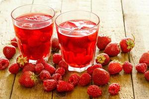 bebida refrescante com framboesa e morango na mesa de madeira foto