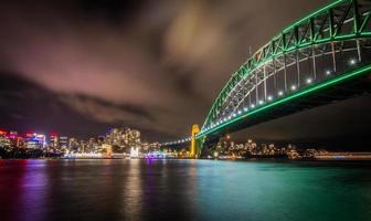 sydney, austrália, 2020 - ponte verde sobre um corpo de água à noite foto