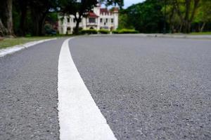 linha branca na estrada de asfalto no parque em foco seletivo. foto