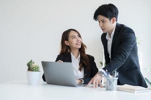 pessoas de negócios discutem empreendimentos comerciais exibindo informações por meio de um notebook foto