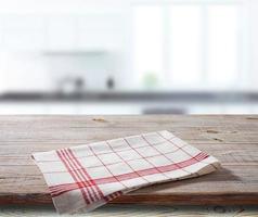 guardanapo branco, toalha de mesa na maquete de deck de madeira. fundo interior da cozinha foto