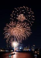 celebração de fogos de artifício no rio no céu escuro foto