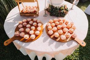 cupcakes gourmet com cobertura de creme de manteiga branco e confeitos em fundo de madeira foto