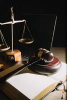 livros de direito e escalas de justiça na mesa na biblioteca do escritório de advocacia. conceito de educação jurídica de jurisprudência. foto