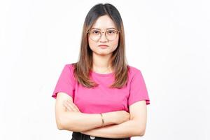 braços cruzados e expressão de rosto zangado de linda mulher asiática isolada no fundo branco foto