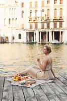 linda mulher está fazendo piquenique em um píer em veneza