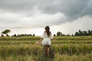 mulher despreocupada usando chapéu de palha no campo de arroz foto