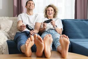 casal com gamepads está jogando videogame em casa foto