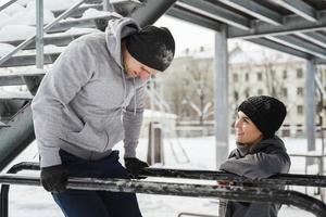 jovem casal esportivo durante treino de calistenia durante o inverno e dia de neve foto