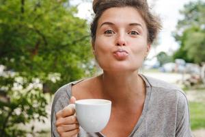 jovem mulher bonita bebendo café no café ao ar livre. foto