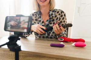 blogueira mulher fazendo vlog e revisando diferentes brinquedos sexuais foto