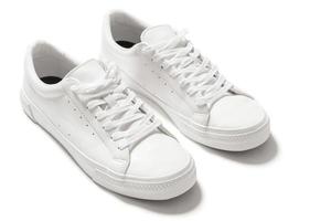 par de tênis de couro branco sobre fundo branco foto