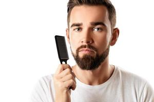 homem bonito e bem preparado, penteando a barba foto