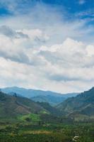 fundo de belas montanhas verdes e céu azul com nuvens foto