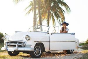 mulher jovem feliz e carro conversível retrô foto