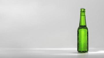 garrafa de cerveja verde com conta-gotas no fundo branco foto