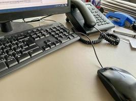 teclado de mouse de computador moderno preto e telefone em uma mesa de escritório de trabalho em uma empresa de negócios foto