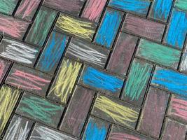 a textura da superfície do piso de lajes de pavimentação, pintada com gizes de cera infantis multicoloridos e brilhantes. o fundo foto