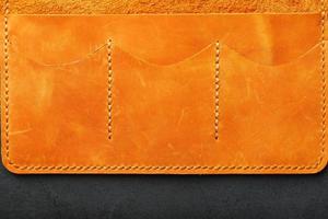 bolsa marrom, carteira feita de nobuck de couro genuíno em um fundo escuro. elementos de produtos artesanais de couro feitos à mão foto